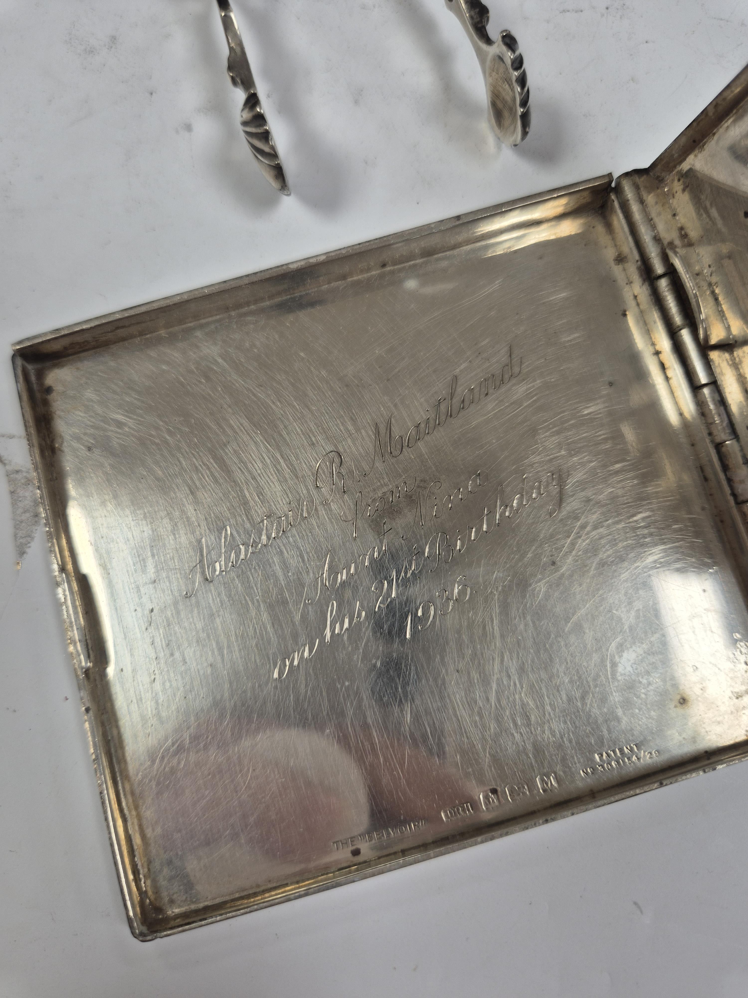 A 1930's engine turned silver cigarette case, 88mm, two silver napkin rings, a white metal miniature model of a boat and a pair of Georgian silver sugar tongs (a.f.). Condition - poor to fair